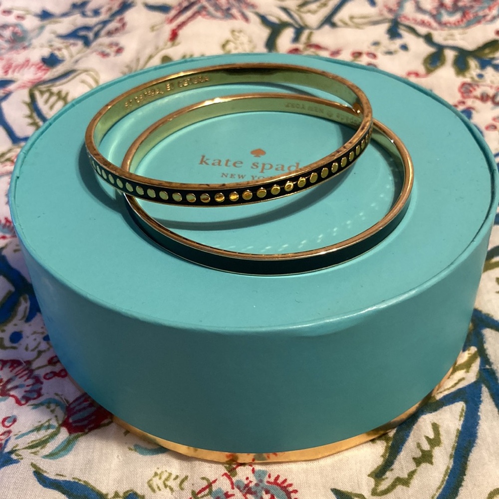 Two Kate Spade black and gold bangles, Draw the Line and Etcetera.